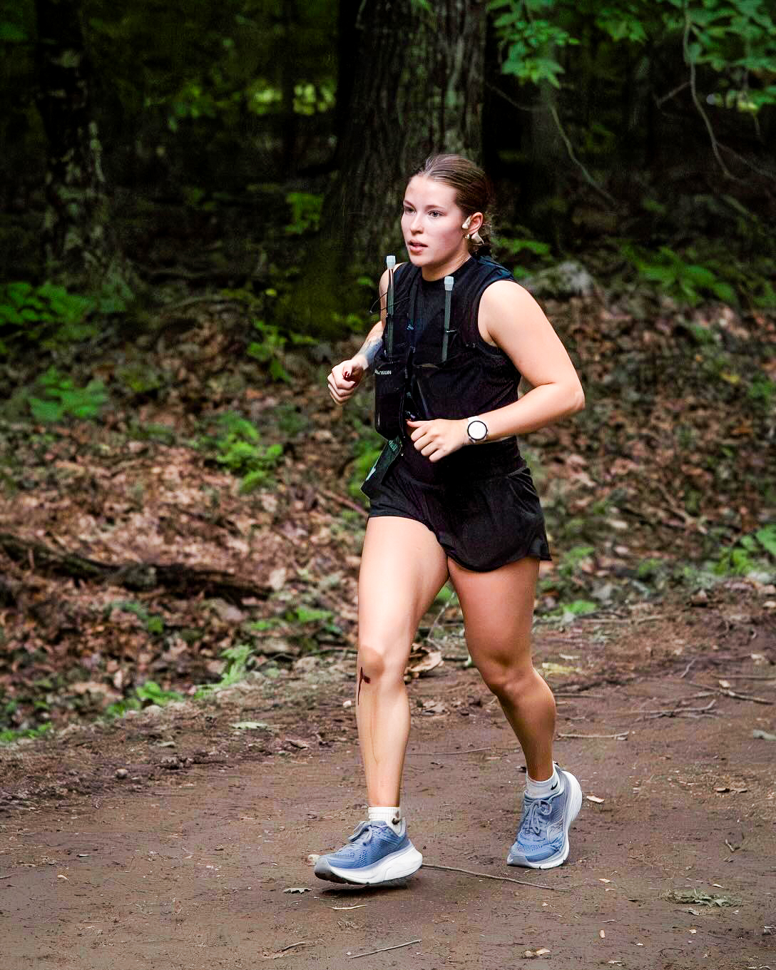 Emily, a two-time ultra marathon runner, racing outdoors during an ultra marathon, showcasing her endurance and focus.